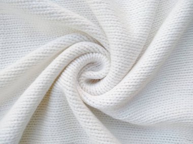 Yün ipliğinden örülmüş giysiler. İplik çerçevesi için yün iplik arkaplanı. El sanatları geçmişi için beyaz örgü ipliği