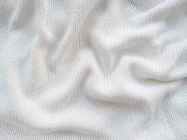 Yün ipliğinden örülmüş giysiler. İplik çerçevesi için yün iplik arkaplanı. El sanatları geçmişi için beyaz örgü ipliği