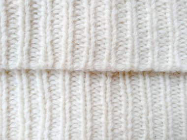 Yün ipliğinden örülmüş giysiler. İplik çerçevesi için yün iplik arkaplanı. El sanatları geçmişi için beyaz örgü ipliği