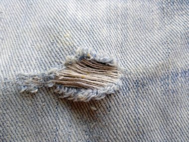Yırtık kot pantolonun dokusu. Yırtık kot pantolon ya da kot kumaş yırtılmış, yırtılmış ve delik