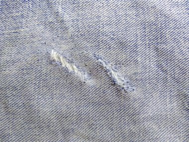 Yırtık kot pantolonun dokusu. Yırtık kot pantolon ya da kot kumaş yırtılmış, yırtılmış ve delik
