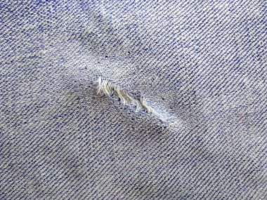 Yırtık kot pantolonun dokusu. Yırtık kot pantolon ya da kot kumaş yırtılmış, yırtılmış ve delik