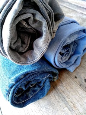 Kot pantolon arka planı. Beyaz arka planda izole edilmiş kot yığını. Kotun kumaşı.