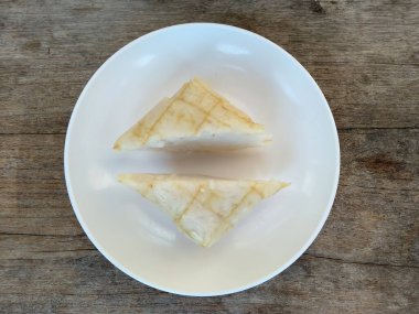 Tahta arka planda Tipat / Ketupat (Rice Dumpling). Ketupat, Bayram Bayramında, İdul Fitri / Aidilfitri 'de pilav pişirmek için genç hindistan cevizi yapraklarından yapılan doğal pirinç kabı.