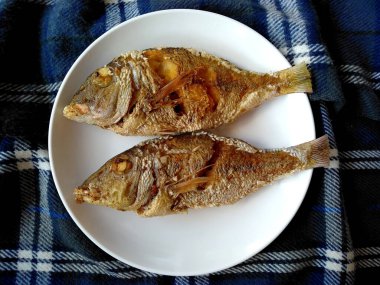 Geleneksel Endonezya mutfağı yemekleri. Ikan Goreng veya kızarmış balık. Ikan Goreng Endonezya yemeği. Basit ve genellikle evde yapılır. Endonezya sokak yiyeceği (kızarmış balık )