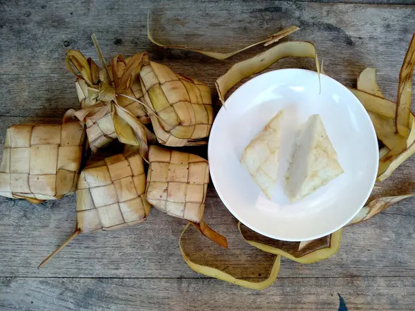 Stock image Tipat / Ketupat ( Rice Dumpling ) On Wooden Background. Ketupat is a natural rice casing made from young coconut leaves for cooking rice during eid Mubarak, Idul Fitri / Aidilfitri