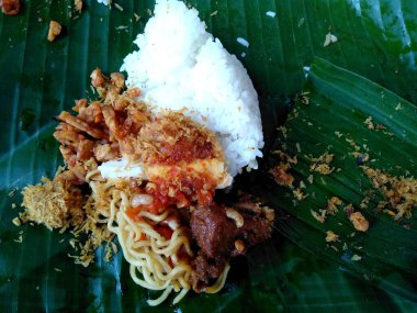 Geleneksel Endonezya mutfağı yemekleri. Makanan Nasi Jinggo Bali / Nasi Kucing veya muz yapraklarına sarılmış pirinç. Nasi Jinggo Endonezya yemekleri basit ve lezzetli. Endonezya Sokak Yemekleri.