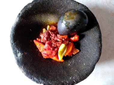 Geleneksel ev yapımı sambal ya da kırmızı acı biber ezmesi. Bir kase acı biber sosu izole edilmiş. Cobek taşı / Ulekan Batu 'da yapılan kırmızı biber sosu. Sambal Endonezya Gıda.