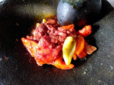 Geleneksel ev yapımı sambal ya da kırmızı acı biber ezmesi. Bir kase acı biber sosu izole edilmiş. Cobek taşı / Ulekan Batu 'da yapılan kırmızı biber sosu. Sambal Endonezya Gıda.