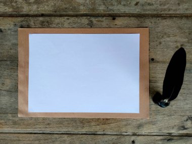 Tüy kalem ve mürekkep hokkası ahşap arka planda izole edilmiş. Bir mesaj yazmak için kalem ve mürekkep )