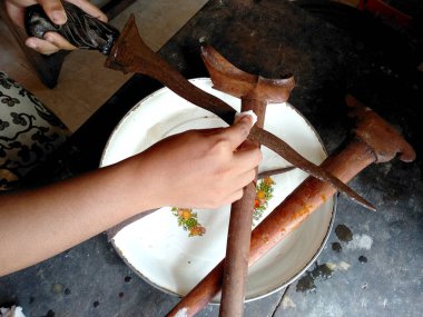 Keris 'i temizliyorum. Keris Endonezya 'nın geleneksel silahıdır. Seçili ütüyü kullanarak elle yapılmış. Sapı ahşap ya da fildişinden yapılmış. (Eski Balili keris )