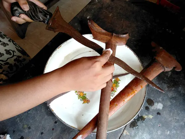 Keris 'i temizliyorum. Keris Endonezya 'nın geleneksel silahıdır. Seçili ütüyü kullanarak elle yapılmış. Sapı ahşap ya da fildişinden yapılmış. (Eski Balili keris )