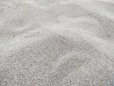 Sahilde gelgit var. Sahilde kum, arka plan olarak. Güneşli bir günde güzel kumsal dokusu. Yazın kumsaldaki kum desenlerinin arka planı ve dokusu