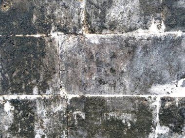 Kirli ve eski kumtaşı duvar dokusu. Yosun, gözenekli, çatlak ve yıpranmış kumtaşı duvarların soyut dokusu. (Duvar dokusu duvar çerçevesi ve duvar arkaplanı olarak kullanılabilir )
