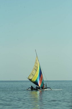 Renkli yelkenli balıkçı tekneleri denizde yüzüyor. Mavi gökyüzü arkaplanı