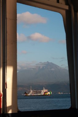 Pencere 'den feribotla Bali Boğazı' nı geçmek arka planı Ijen Dağı olan başka bir feribot gibi görünüyor.