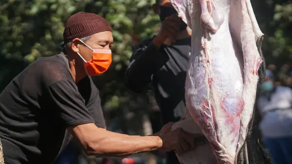 Stock image Eid al-Adha celebration. Muslim people using mask help each other in prepares meat to distribute to the poor during Eid Al-Adha. The Feast of Sacrifice or Qurban.