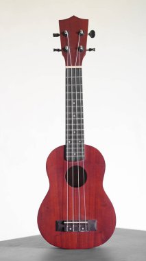 Four stringed ukulele guitar made of wood on a white background