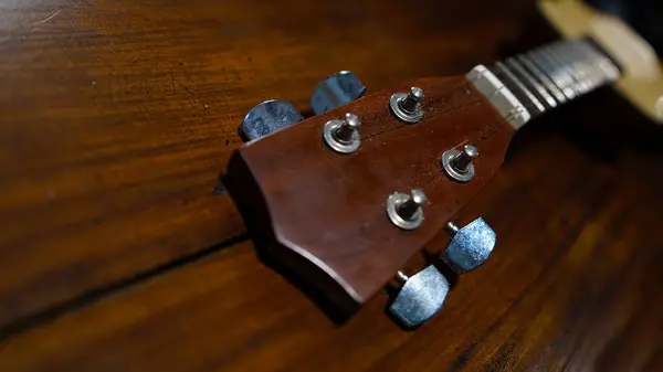 stock image Four stringed ukulele guitar made of wood on a wooden table. Focus selected