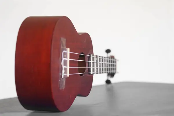 stock image Four stringed ukulele guitar made of wood on a white background. Focus selected