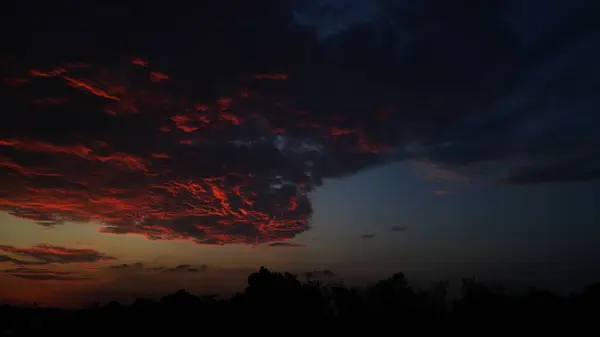 Güneşe maruz kalmış turuncu bulutlu karanlık.