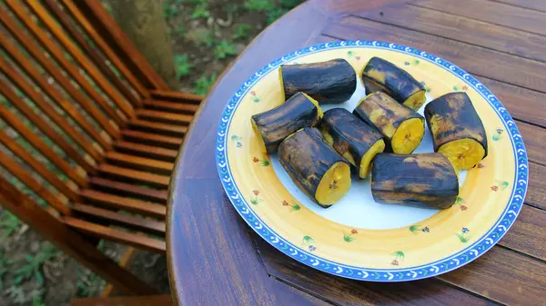 Ahşap bir masada kaynamış muz dilimleri.