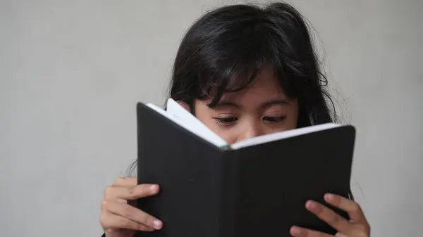 Kızlar kitap okuyor, gözlere odaklanıyor, bulanık kitaplar okuyor.