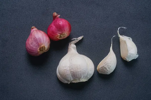 Siyah arka planda soğan ve sarımsak.