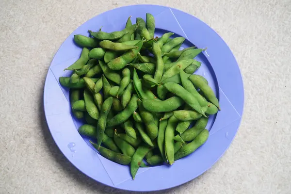 Olgun edamame mor bir tabakta servis edilir.