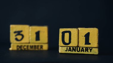 1 Ocak odaklı tahta blok takvimi. 31 Aralık 'ta tahta blokları bulanıklaştırın. Siyah arkaplan