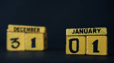 1 Ocak odaklı tahta blok takvimi. 31 Aralık 'ta tahta blokları bulanıklaştırın. Siyah arkaplan