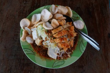 Kupat Tahu, içinde kupat, kızarmış tofu, lahana, fasulye filizi ve fıstık sosu bulunan geleneksel bir Java yemeği. Krakerler de var..