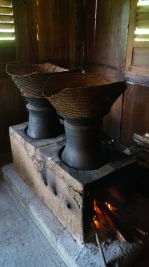 Odunlu geleneksel mutfak. Üzerinde iki kil tava ve bir bambu buharı var. Endonezya 'nın klasik mutfağı