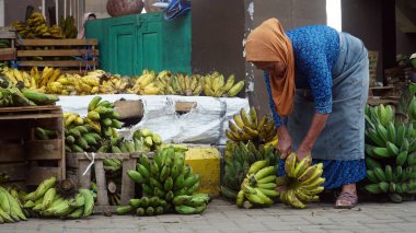 Meyve satan yaşlı bir kadın Muntilan Market 'te muz kesiyor, Magelang.