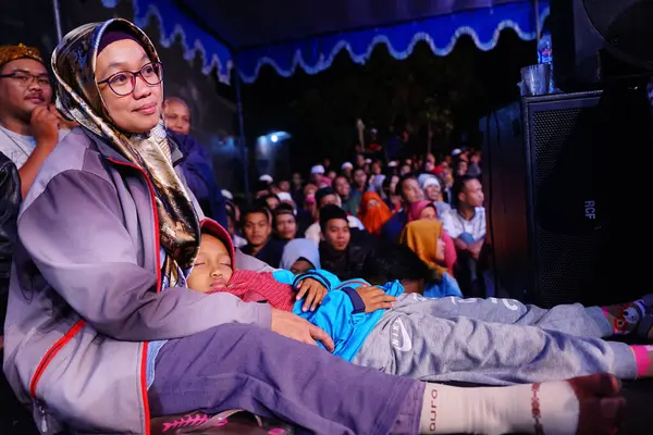 Dini bir etkinlikte kucağında uyuyakalan Müslüman kadın ve çocuk