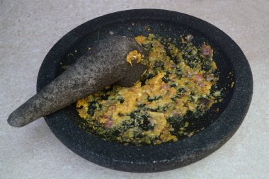 Mutfak baharatları taştan bir havan topuna ezildi.