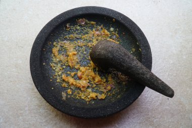 Mutfak baharatları taştan bir havan topuna ezildi.