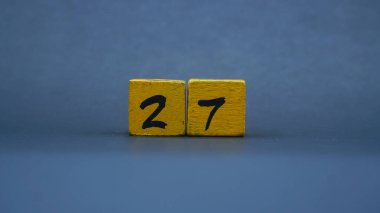Tahta blok, 27 numara. Koyu arkaplanda sarı renk