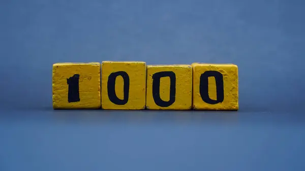 Tahta blok ve 1000 numara. Koyu arkaplanda sarı renk. Seçilene odaklan