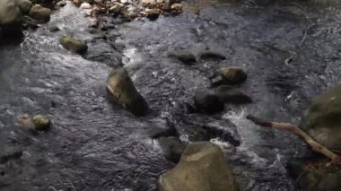 Nehirdeki su akışı, büyük ve küçük kayalar var. Üst görünüm