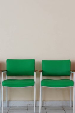 İki boş yeşil sandalye. Düz duvar arkaplanı