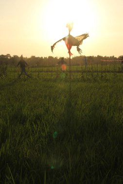 Scarecrow silhouette on sun background. Focus selected clipart