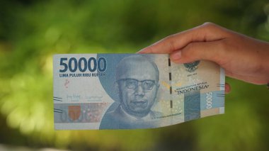 Endonezya parası, 50,000 rupiah banknot, bir kadının elinde. Seçilene odaklan