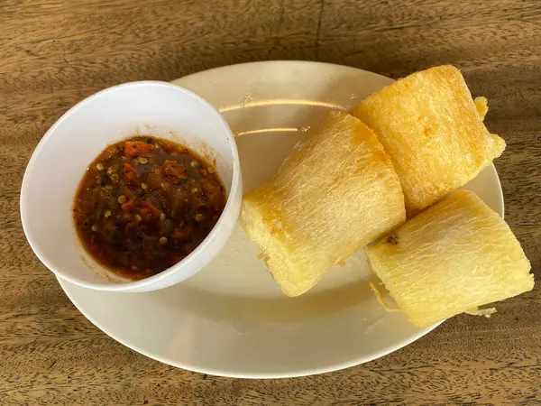 stock image Slices of fried cassava and chili sauce on a white plate. Focus selected