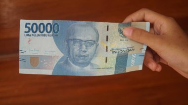 Endonezya parası, 50,000 rupiah banknot, bir kadının elinde. Seçilene odaklan
