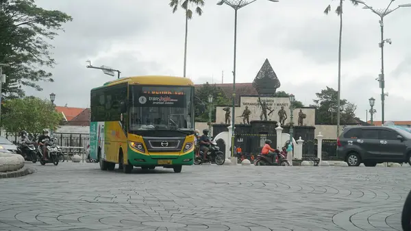 stock image The Trans Jogja bus passes at the point O km with the SO1M Monument in the background