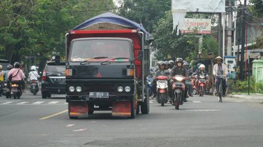 Bantul yolunda trafik vardı. Siyah kamyona odaklan. Diğer araçlar odak dışı