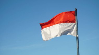 Rüzgarda dalgalanan kırmızı ve beyaz bayrak mavi arkaplan