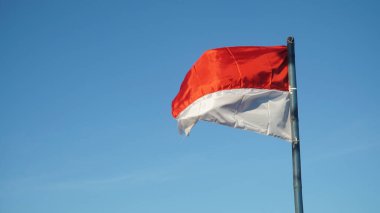 Rüzgarda dalgalanan kırmızı ve beyaz bayrak mavi arkaplan