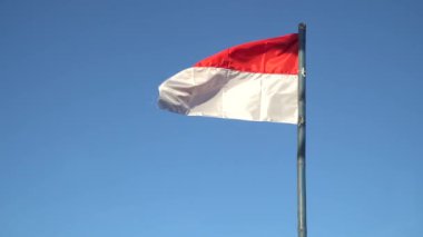 Rüzgarda dalgalanan kırmızı ve beyaz bayrak mavi arkaplan